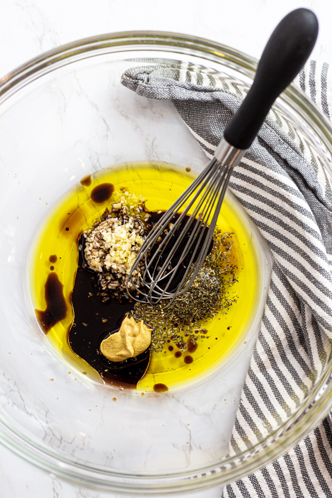 olive oil, balsamic vinegar, minced garlic, Dijon mustard, Italian herbs, and pepper in a bowl before mixing