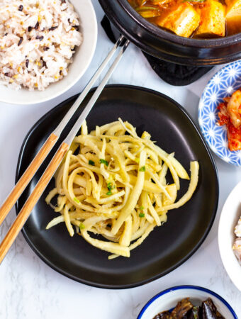 bellflower roots (doraji namul) with a bowl of rice and other Korean side dishes around it