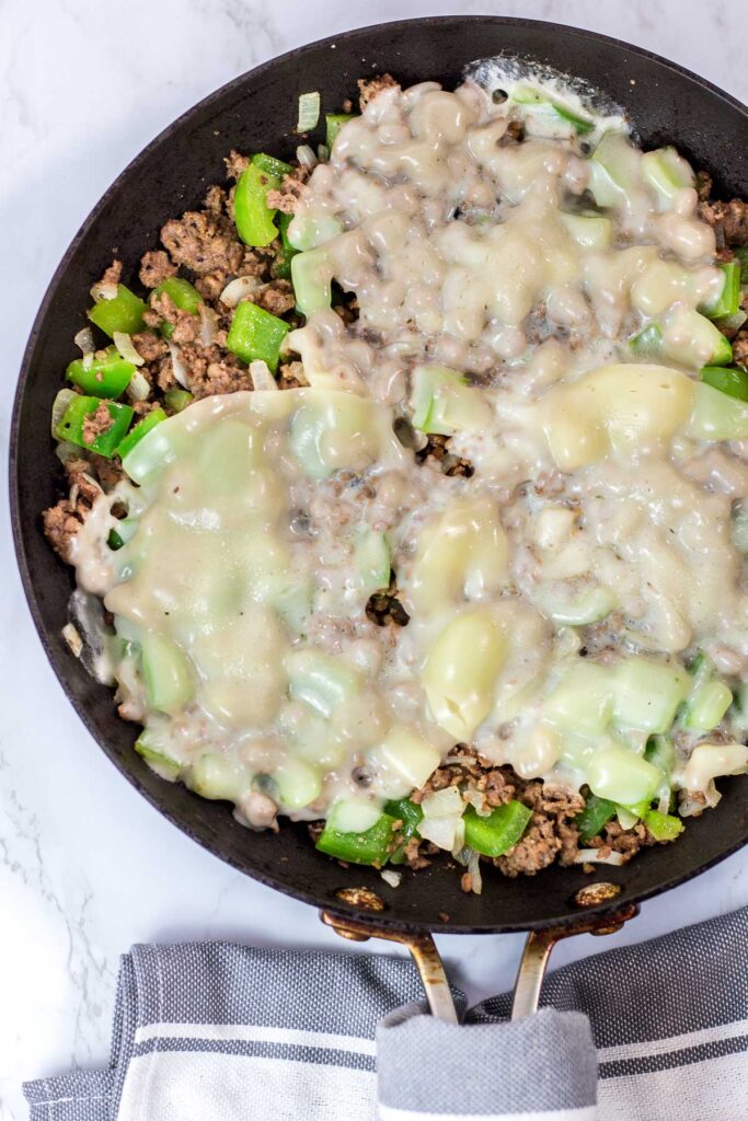 melty provolone cheese on top of vegetarian philly cheesesteak sloppy joes in the pan