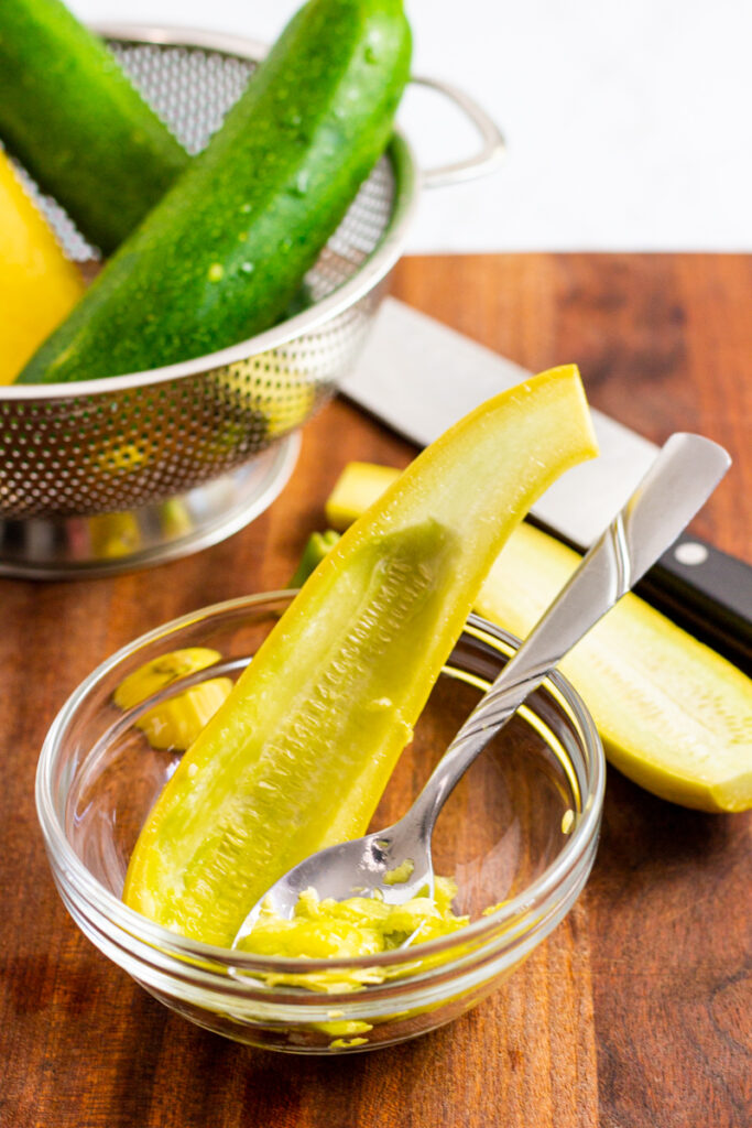 scraping the yellow squash seeds with a spoon.