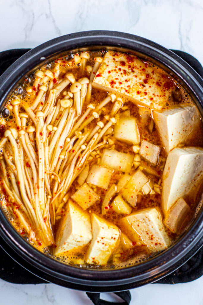 tofu and enoki mushroom added to the base soup.