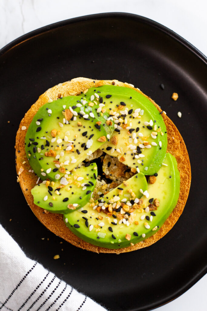 avocado slices on top of toasted bagel.