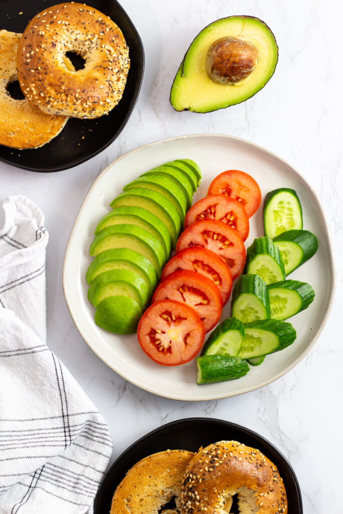 avocado, tomato, and cucumber slices with toasted everything bagels.