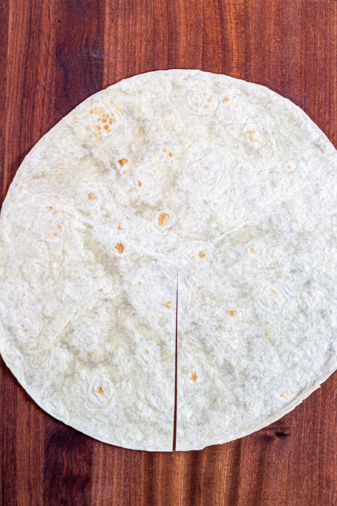 A large flour tortilla with a halfway cut from the center to the edge.