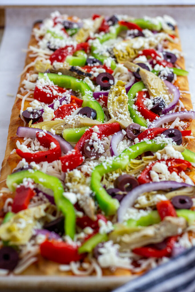 Loaded veggie Mediterranean pizza before baking.