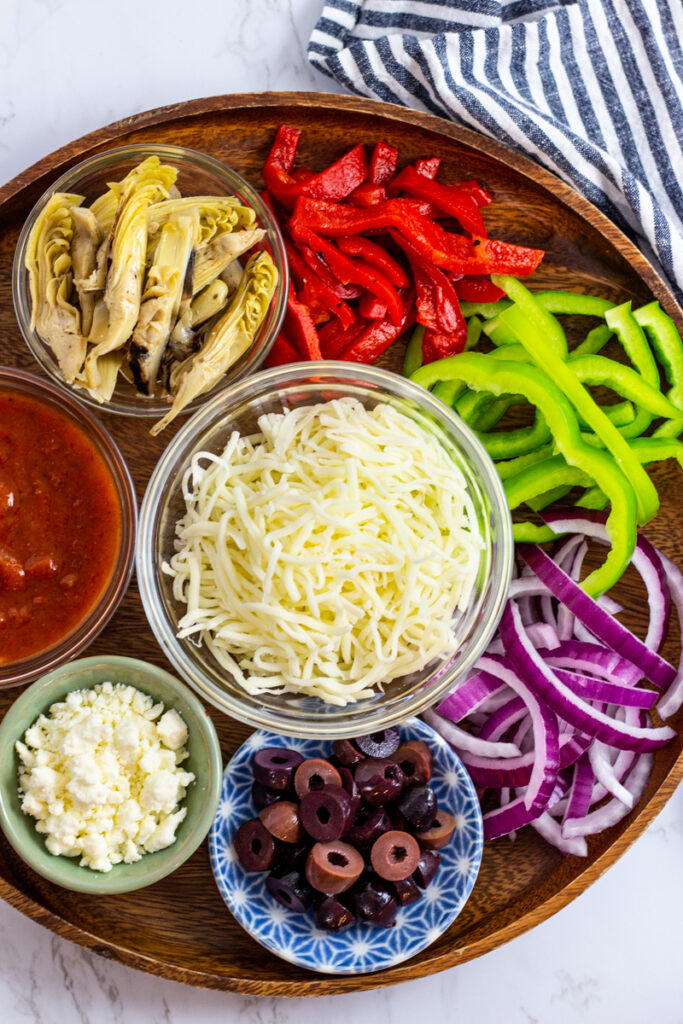 Toppings - roasted red bell pepper, fresh green bell pepper, red onion, olive, artichoke hearts, and cheese.