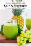 close up photo of green smoothie with kale, pineapple, and grape in the background.