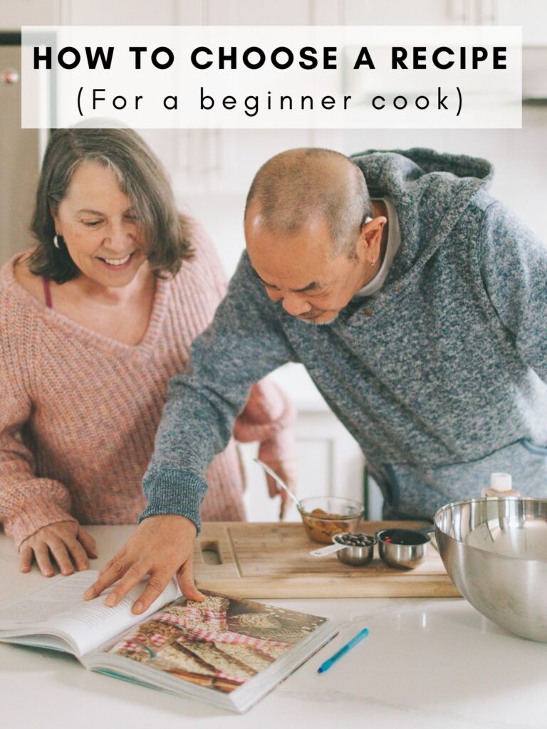 An older couple looking at a cookbook to bake something. 