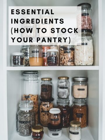 Different spices, legumes, nuts, and seeds are in glass jars in the pantry.