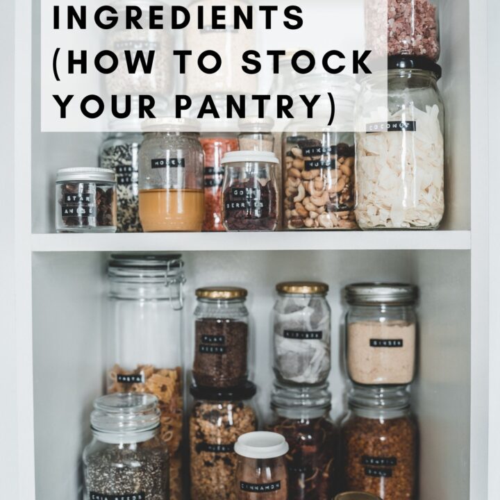 Different spices, legumes, nuts, and seeds are in glass jars in the pantry.