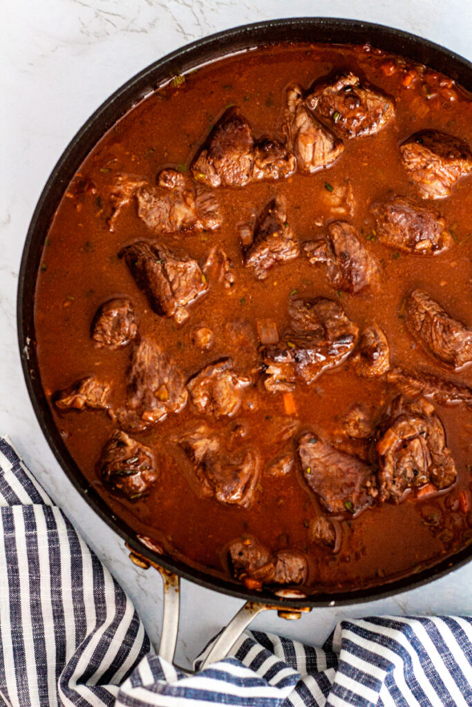 Addition of the beef broth and beef back to the pan.