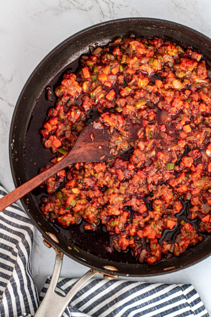 Add brandy and red wine to the pan to deglaze.