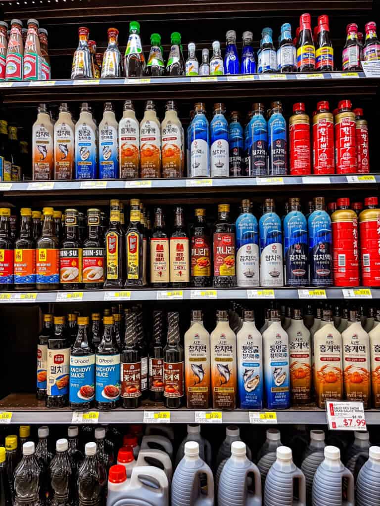 Aisle view of Korean fish sauces including anchovy, tuna, and seafood-based sauces at HMart