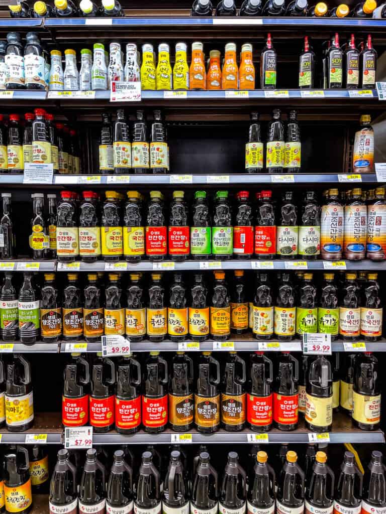 A full shelf of Korean soy sauces including Jin Ganjang, Guk Ganjang, and Yangjo Ganjang at HMart