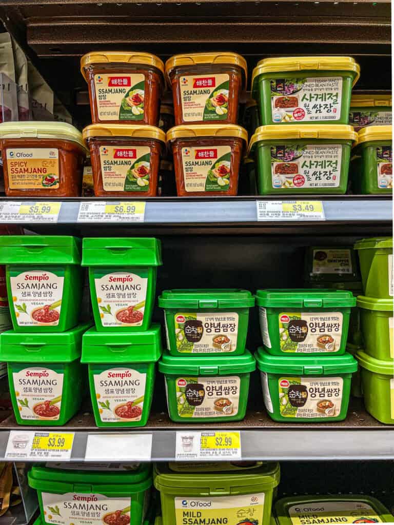 Shelf of Korean ssamjang seasoned soybean paste from Sempio, O’Food, and other brands used for lettuce wraps
