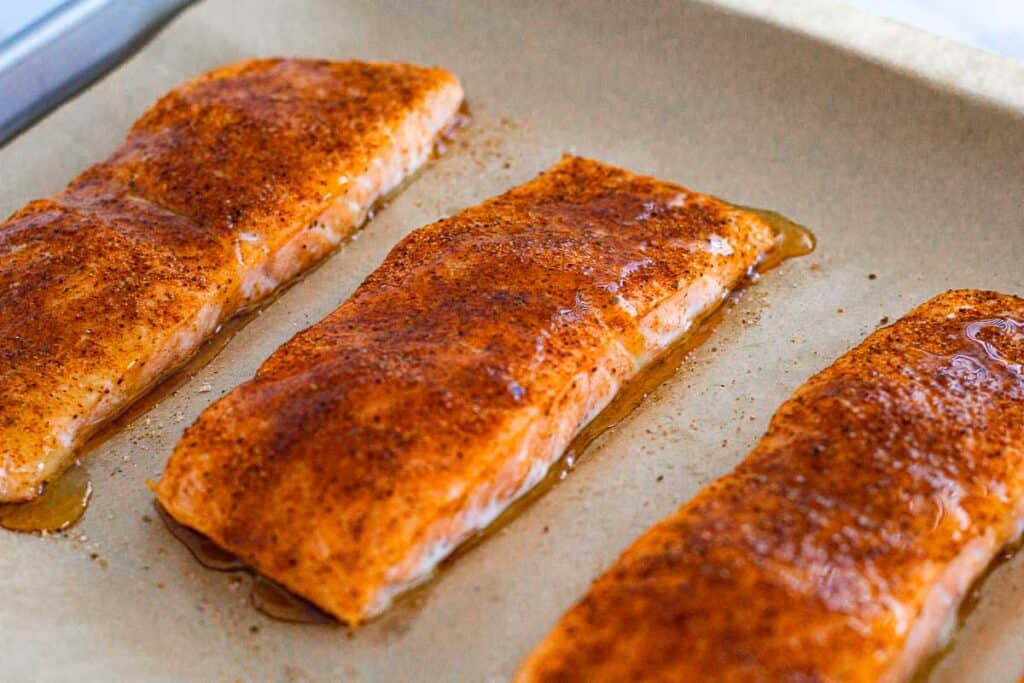 baked salmon fillets with glistening hot honey glaze pooling on parchment paper