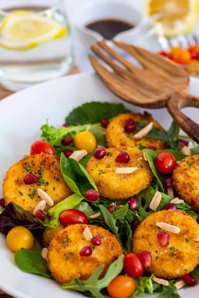 Mixed greens salad with fried goat cheese, cherry tomatoes, pomegranate seeds, and almonds