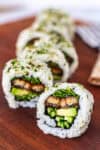 Close-up of unagi roll showing grilled eel, cucumber, and sprouts inside rice and nori