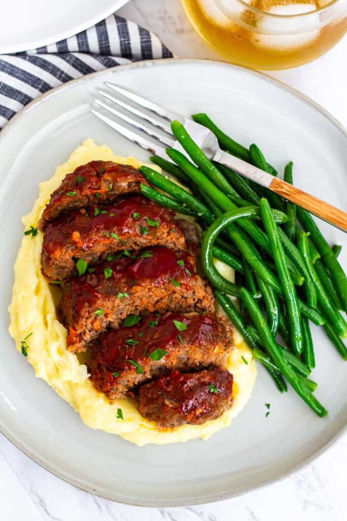 Dinner plate with glazed mini meatloaf, mashed potatoes, and sautéed green beans
