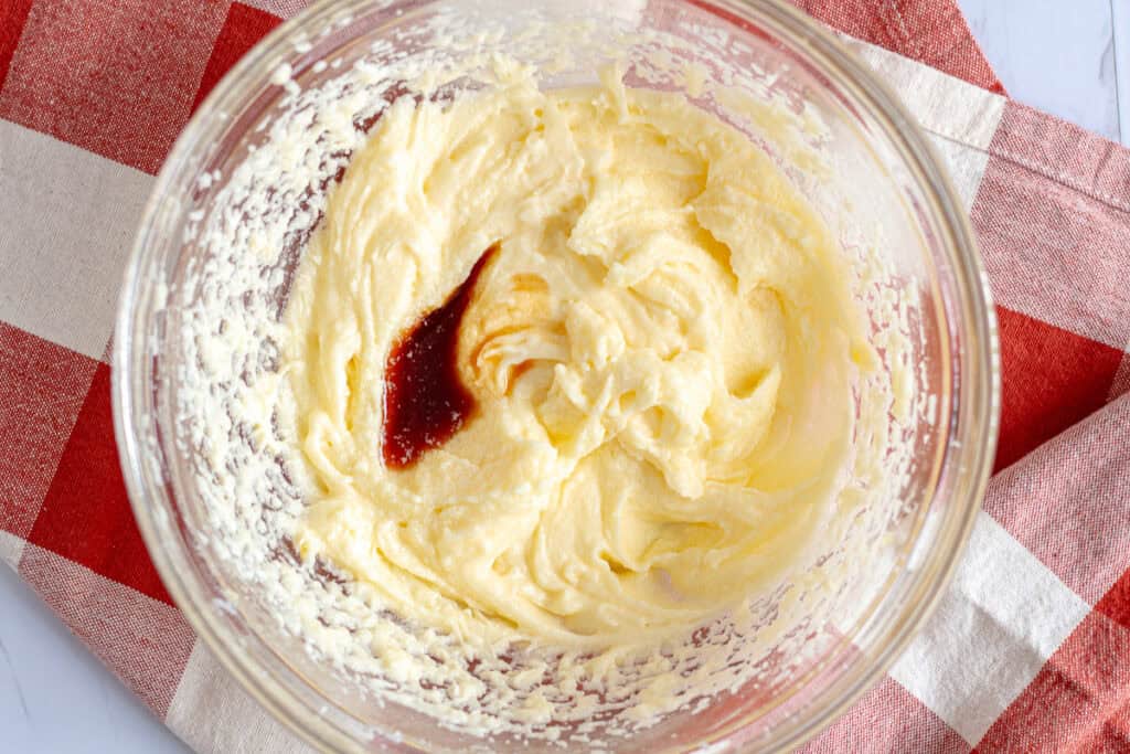 Butter and sugar creamed together in a glass bowl with vanilla added for mini spiced apple cake batter