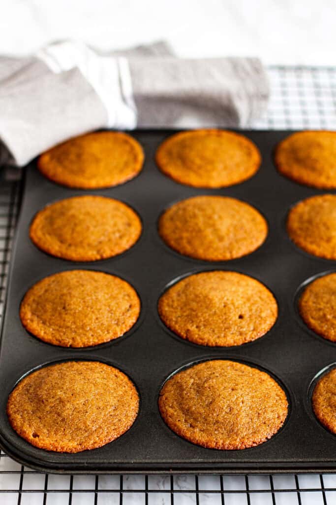 Mini sticky toffee pudding cakes baked in muffin tin and cooling on rack