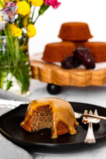 Sticky toffee pudding with bite showing soft moist texture and glossy toffee sauce