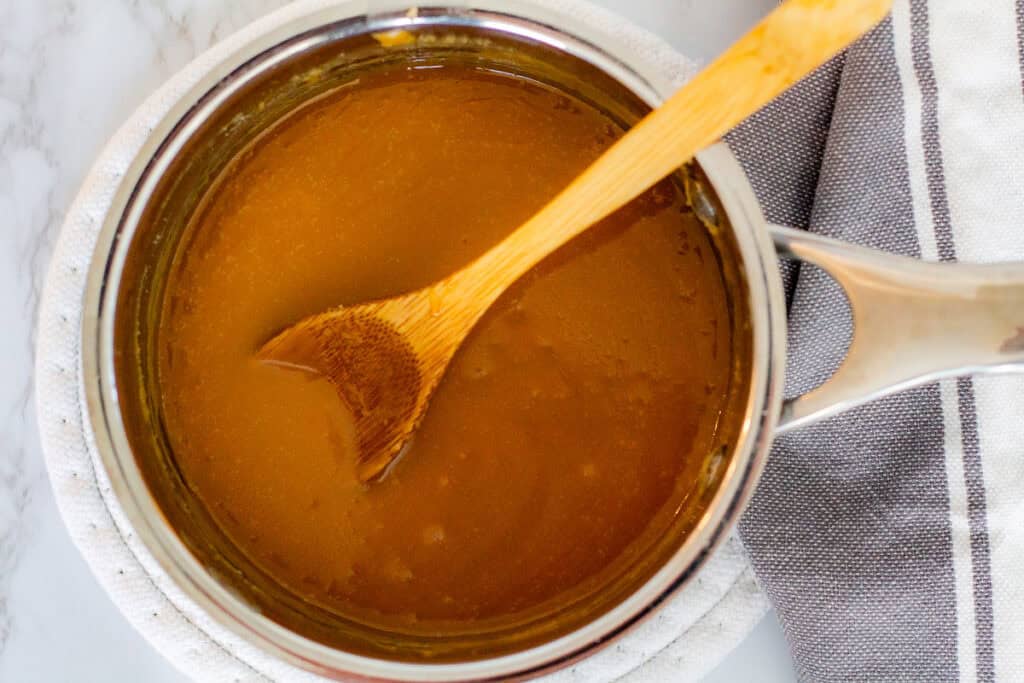 Warm toffee sauce in saucepan for sticky toffee pudding recipe