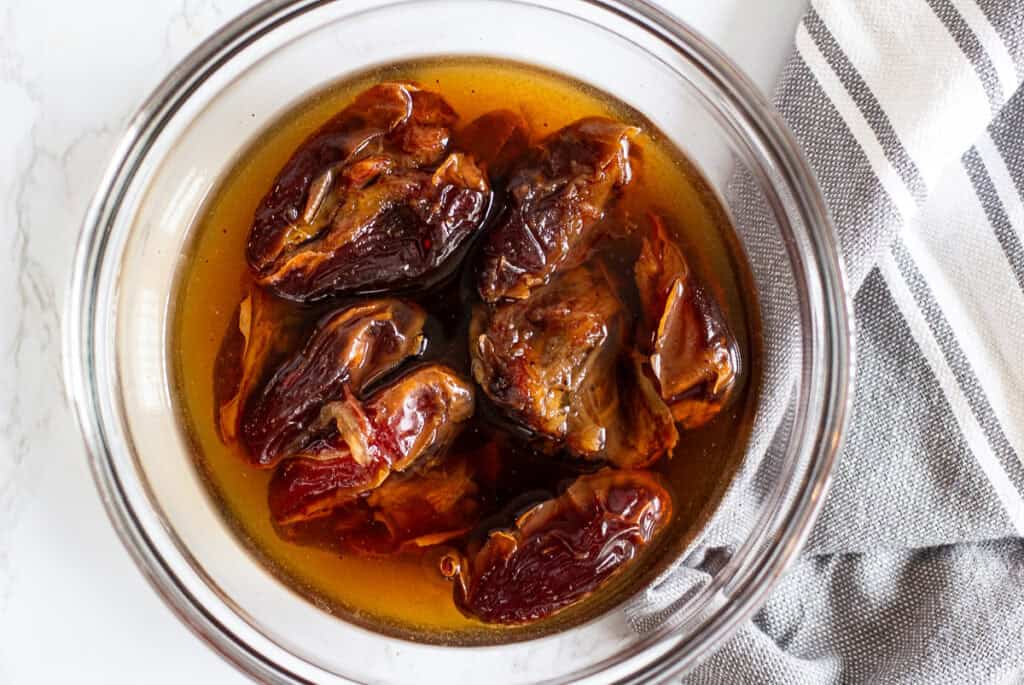 Medjool dates soaking in hot espresso water for sticky toffee pudding recipe