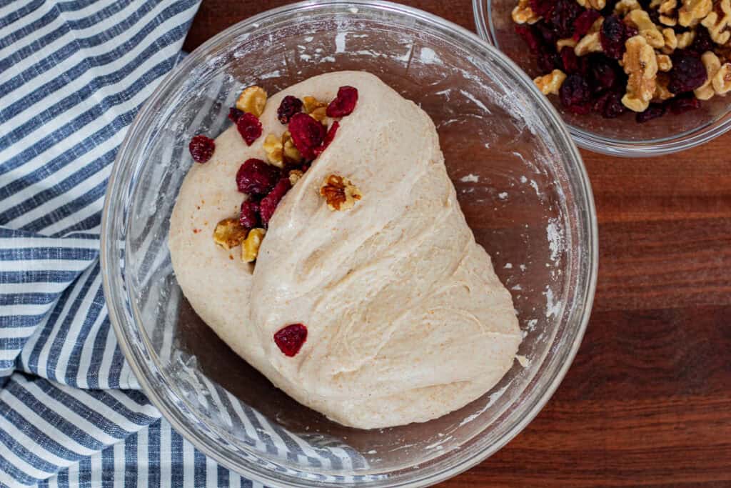 First portion of dried cranberries and toasted walnuts folded into the dough.