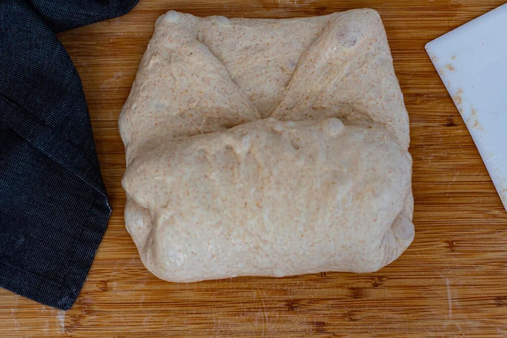 Dough folded up from the bottom to prepare the sourdough discard bread for final shaping.