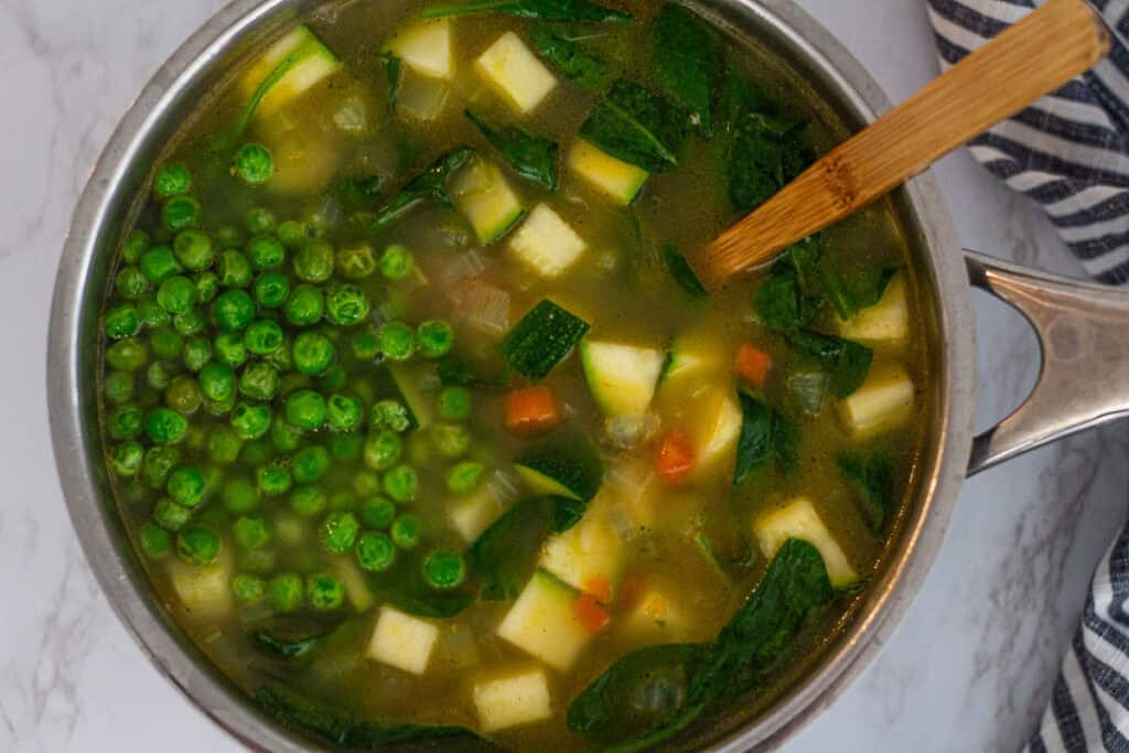 Frozen peas and spinach stirred into soup near the end of cooking.