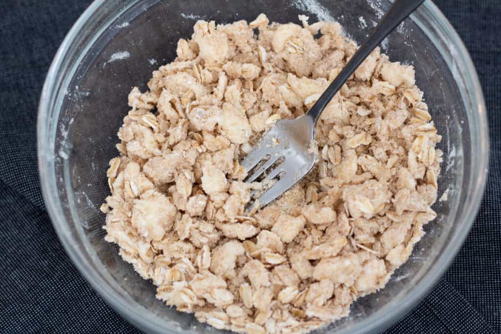 Mixing oat crumble topping for cherry crisp until coarse and crumbly
