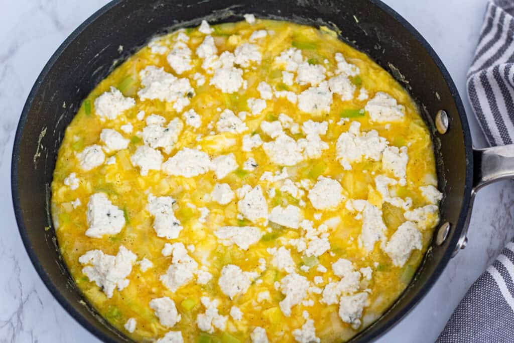 Crumbled Boursin cheese added to leek frittata before baking.