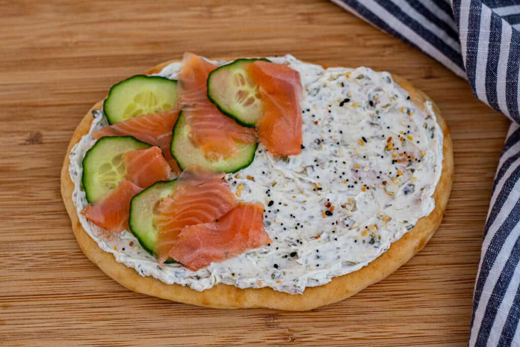 Cucumber slices and smoked salmon layered over cream cheese on flatbread.