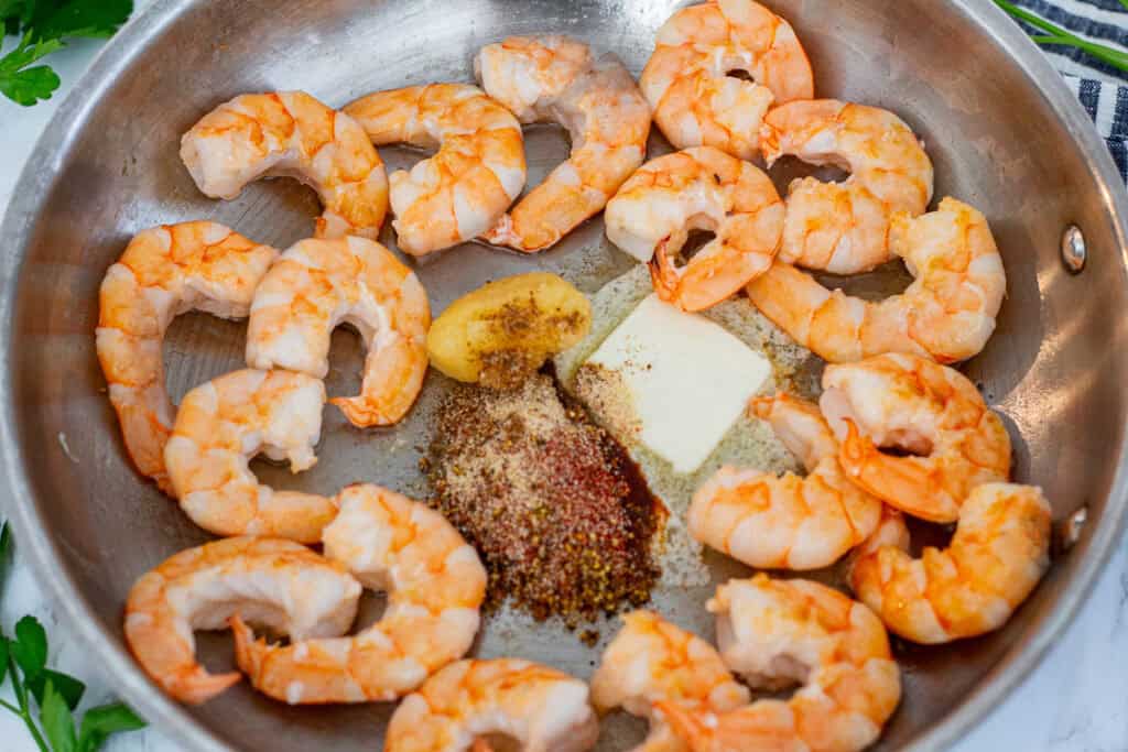 Shrimp flipped in a skillet with melted butter, garlic, and seafood boil seasoning.