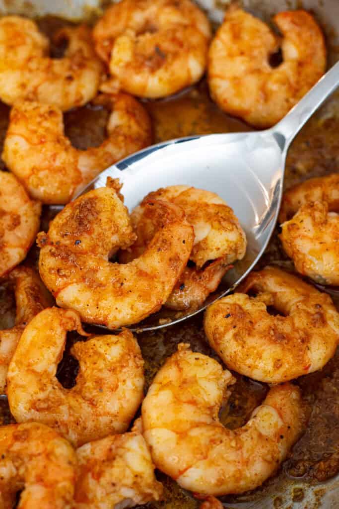 Close-up of cooked spicy garlic butter shrimp coated in a glossy garlic butter sauce.