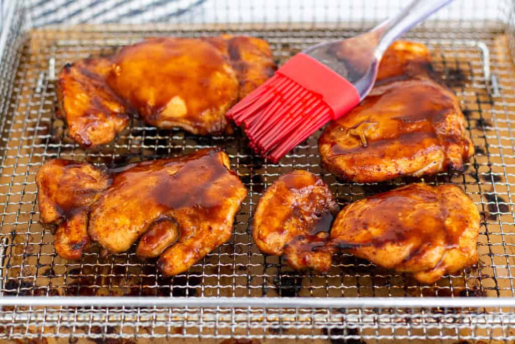 brushing thick teriyaki glaze onto air fryer chicken thighs