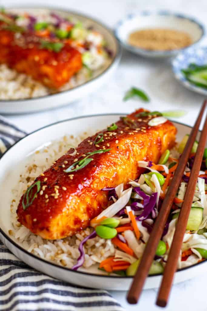 caramelized salmon with glossy glaze served over rice with fresh vegetables