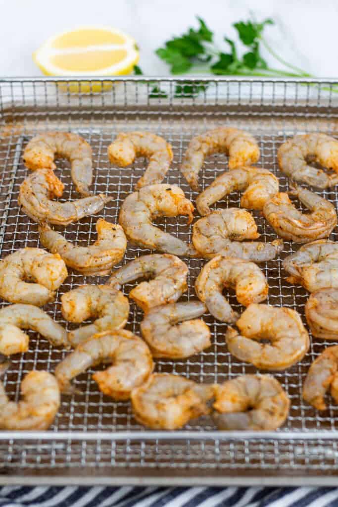 Seasoned raw shrimp arranged on a rack before air frying