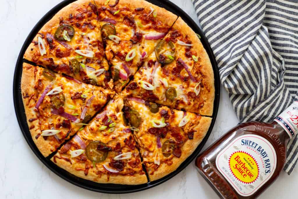 Homemade BBQ chicken and bacon pizza baked until golden brown and topped with sliced green onions.