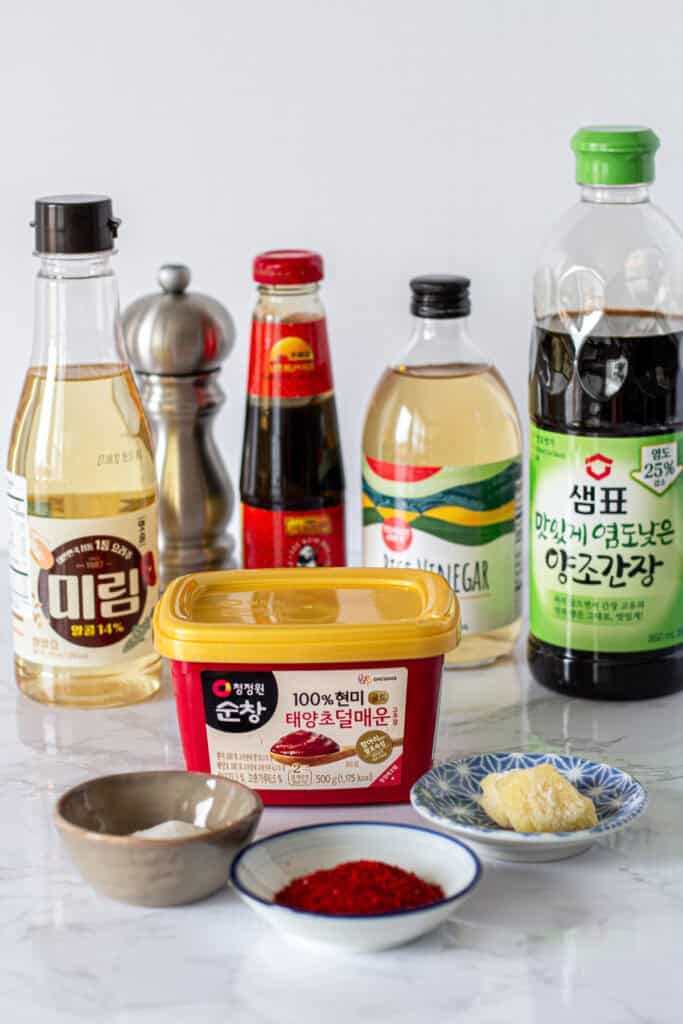 Ingredients for gochujang ground pork including gochujang, gochugaru, soy sauce, oyster sauce, mirin, garlic, rice vinegar, sugar, and black pepper.