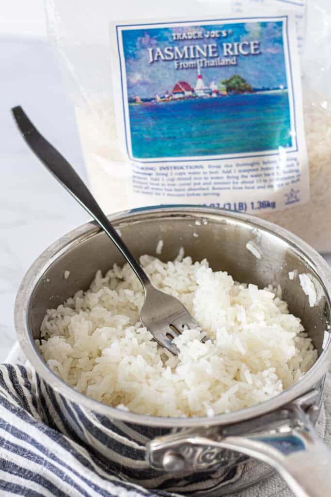 Fluffing cooked jasmine rice with a fork before serving
