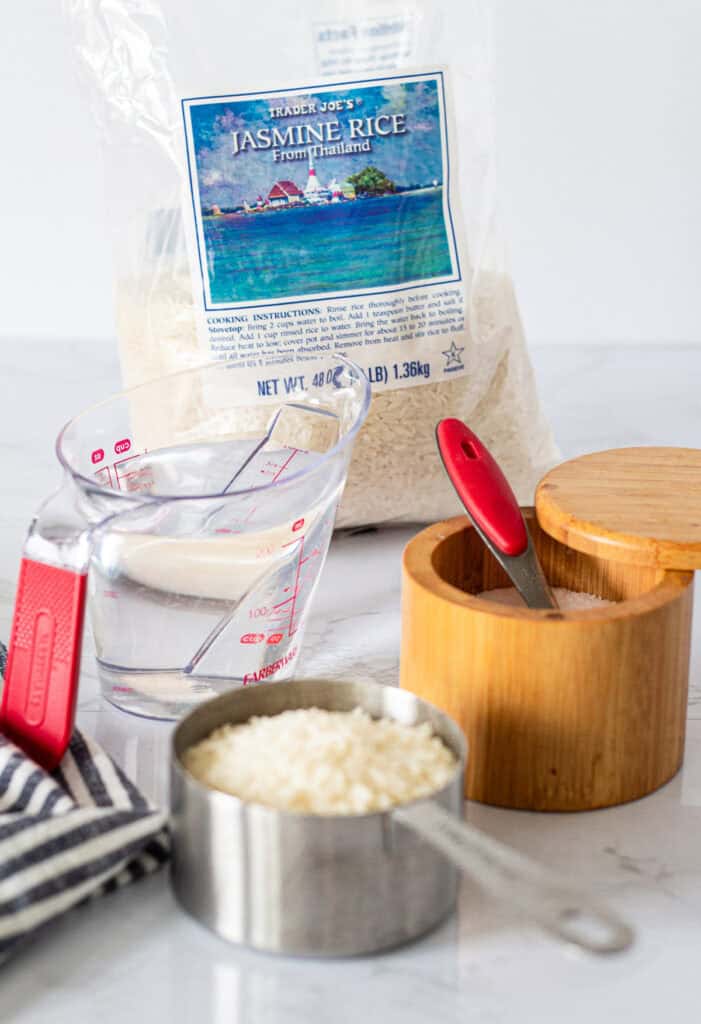 Ingredients for making jasmine rice for two, including jasmine rice, water, and kosher salt