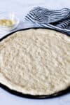 Small batch pizza dough shaped into a 10- to 12-inch crust on a pizza pan before adding toppings.