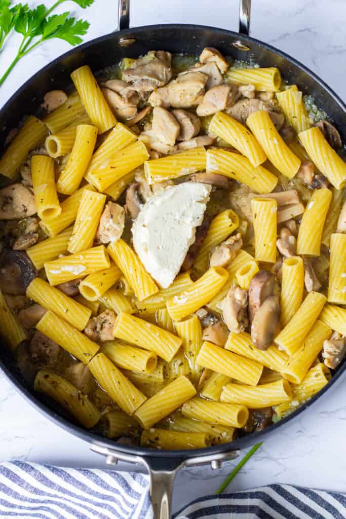 Garlic and herb Boursin cheese added to cooked rigatoni, chicken, and mushrooms