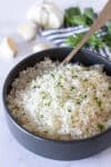 Bowl of fluffy garlic basmati rice garnished with fresh parsley