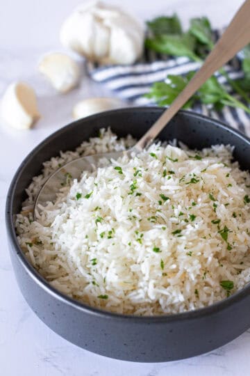 Bowl of fluffy garlic basmati rice garnished with fresh parsley