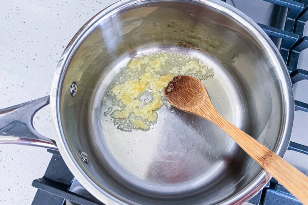 Minced garlic just added to olive oil in a saucepan before it turns lightly golden