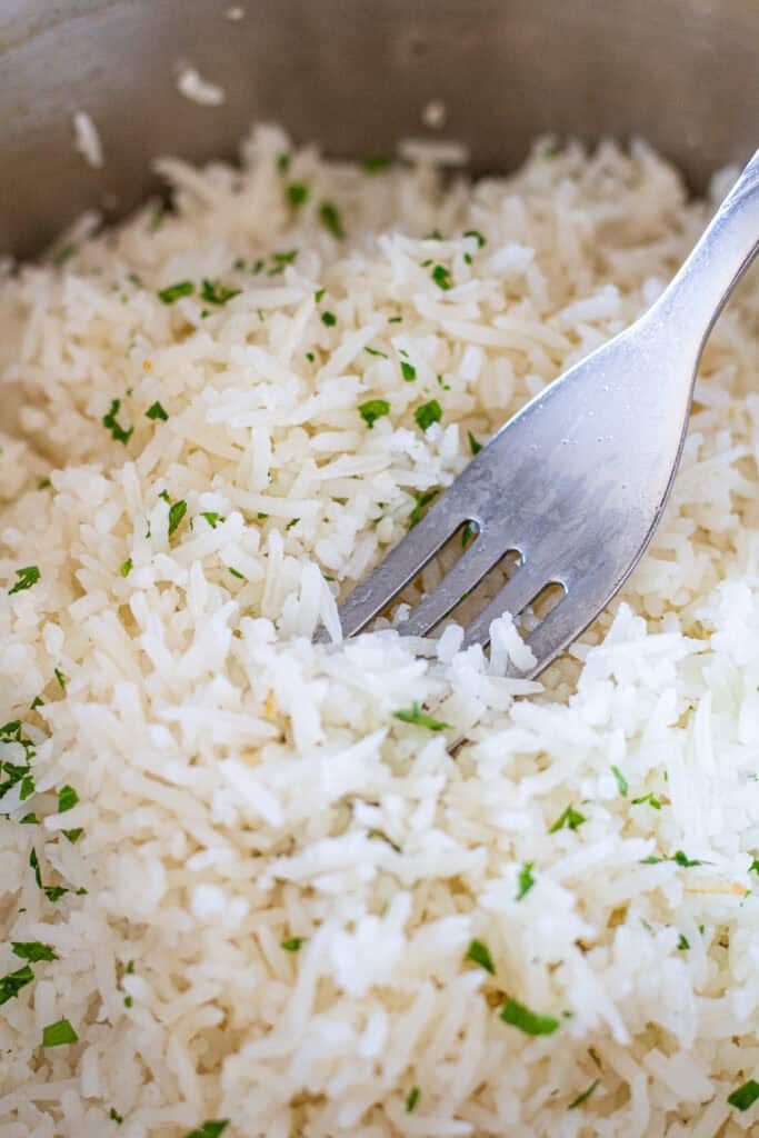 Close-up of fluffy garlic basmati rice being fluffed with a fork