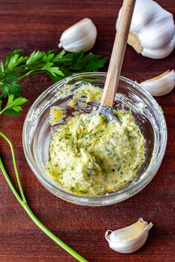 Garlic butter mixture with fresh parsley and Parmesan in a small glass bowl